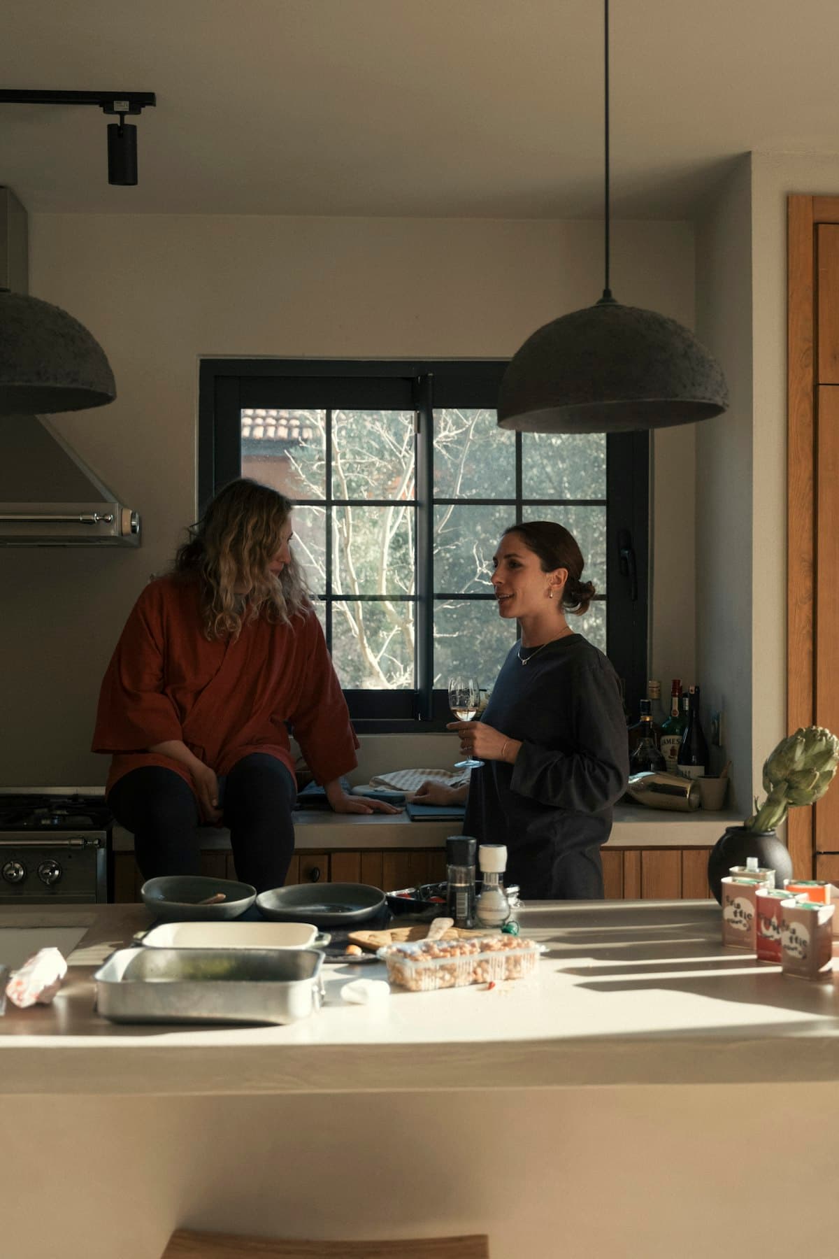 Two people talking while cooking in a home kitchen